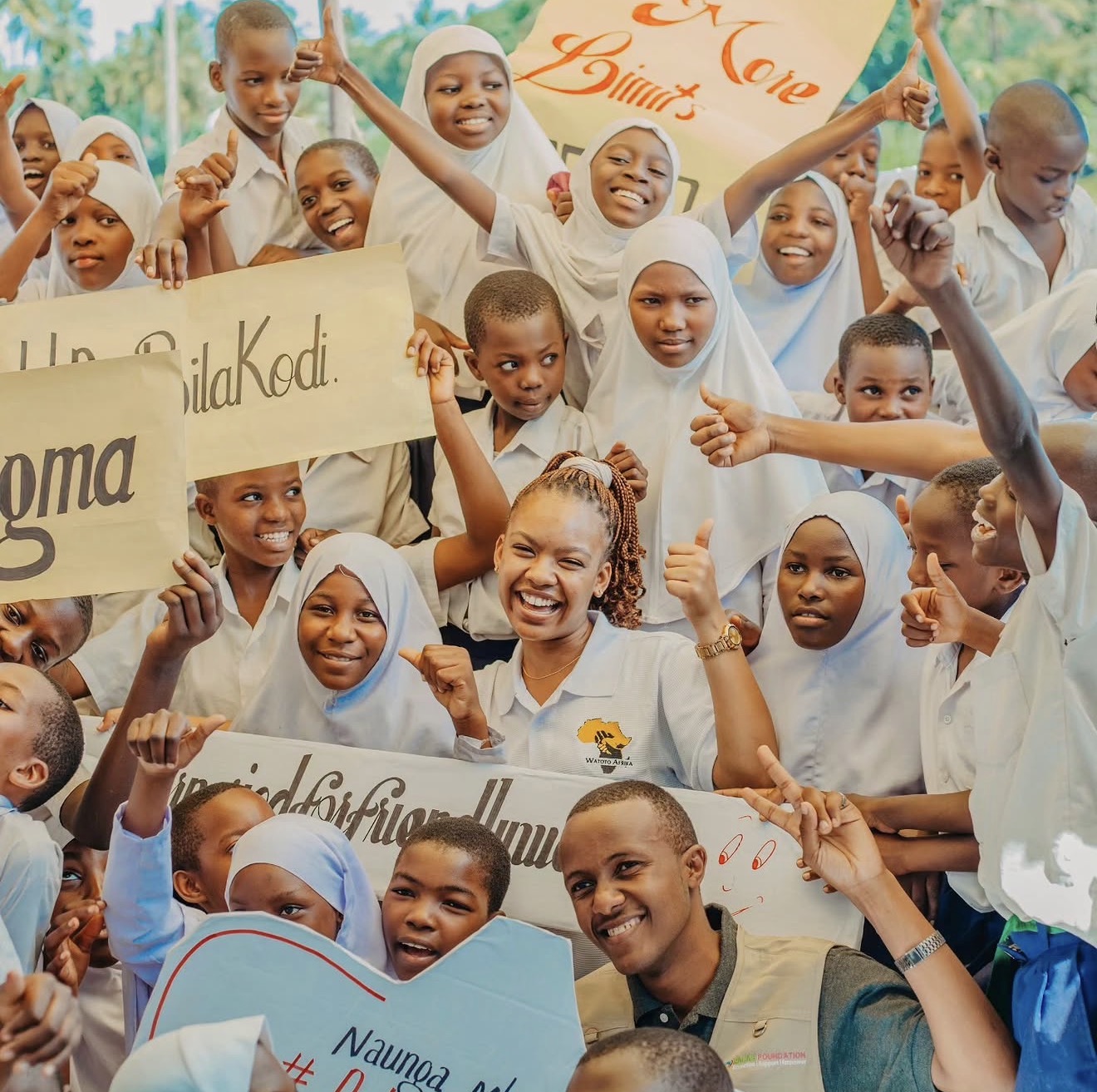 Tanzanian students celebrating with advocacy signs